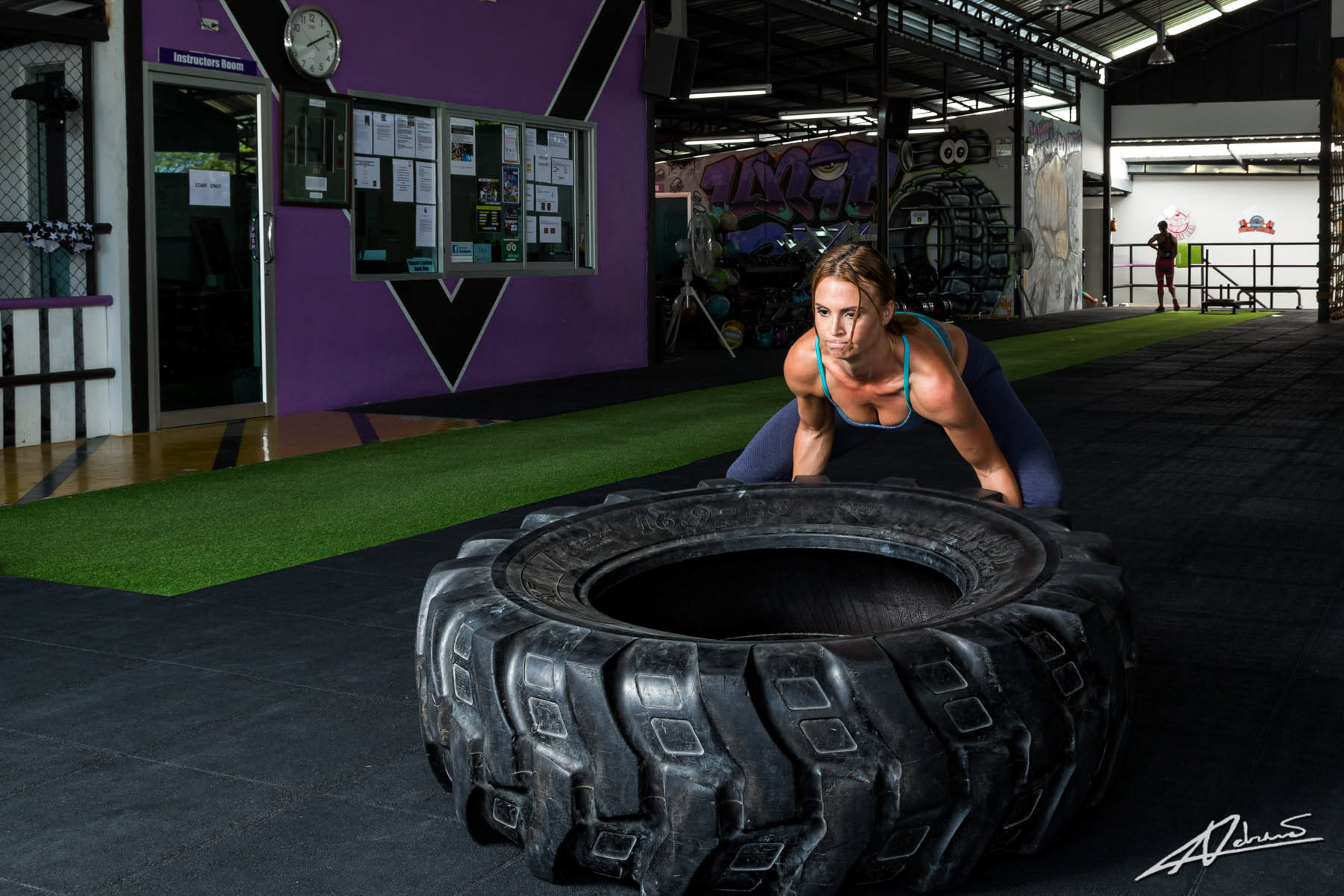 Fitness photography woman training with a tyre.