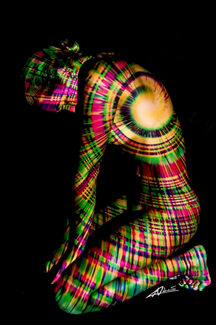 Projections-nude photography woman sitting on knees with colorfull picture.